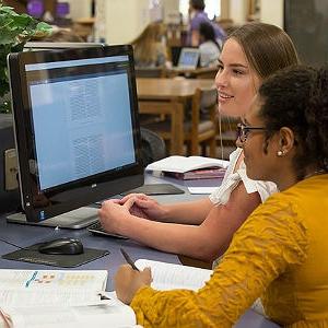 大学生坐在图书馆的电脑前学习